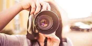 Frau mit Spiegelreflexkamera fotografiert in Kamera