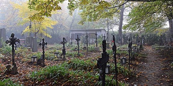 Mystischer Friedhof, schwarze Kreuez an einem düsteren Herbsttag