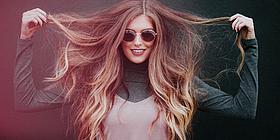 Frau mit wallender Mähne hält ihre Haare hoch