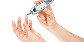 Blutzuckermessgerät mit Stechen Diabetiker misst Blutzuckerwerte mittels Nadel und Teststreifen über Blut das aus dem Finger tropft.