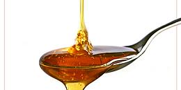 Honig, der auf einen Löffel gegossen wird