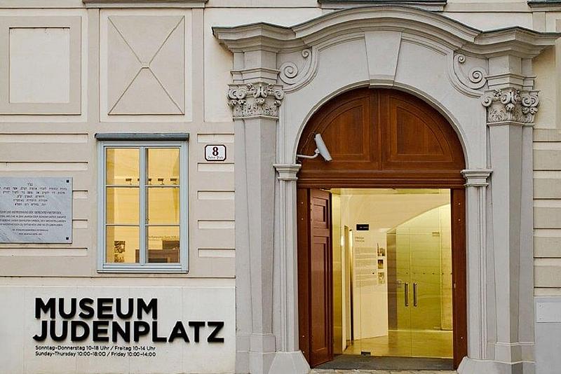 Haupteingang Museum am Judenplatz mit bunten Fenstern, die das Symbol Davidstern zeigen.
