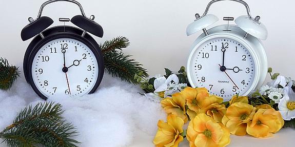 Zwei klassische Wecker, einer zeigt drei Uhr, einer zwei Uhr an