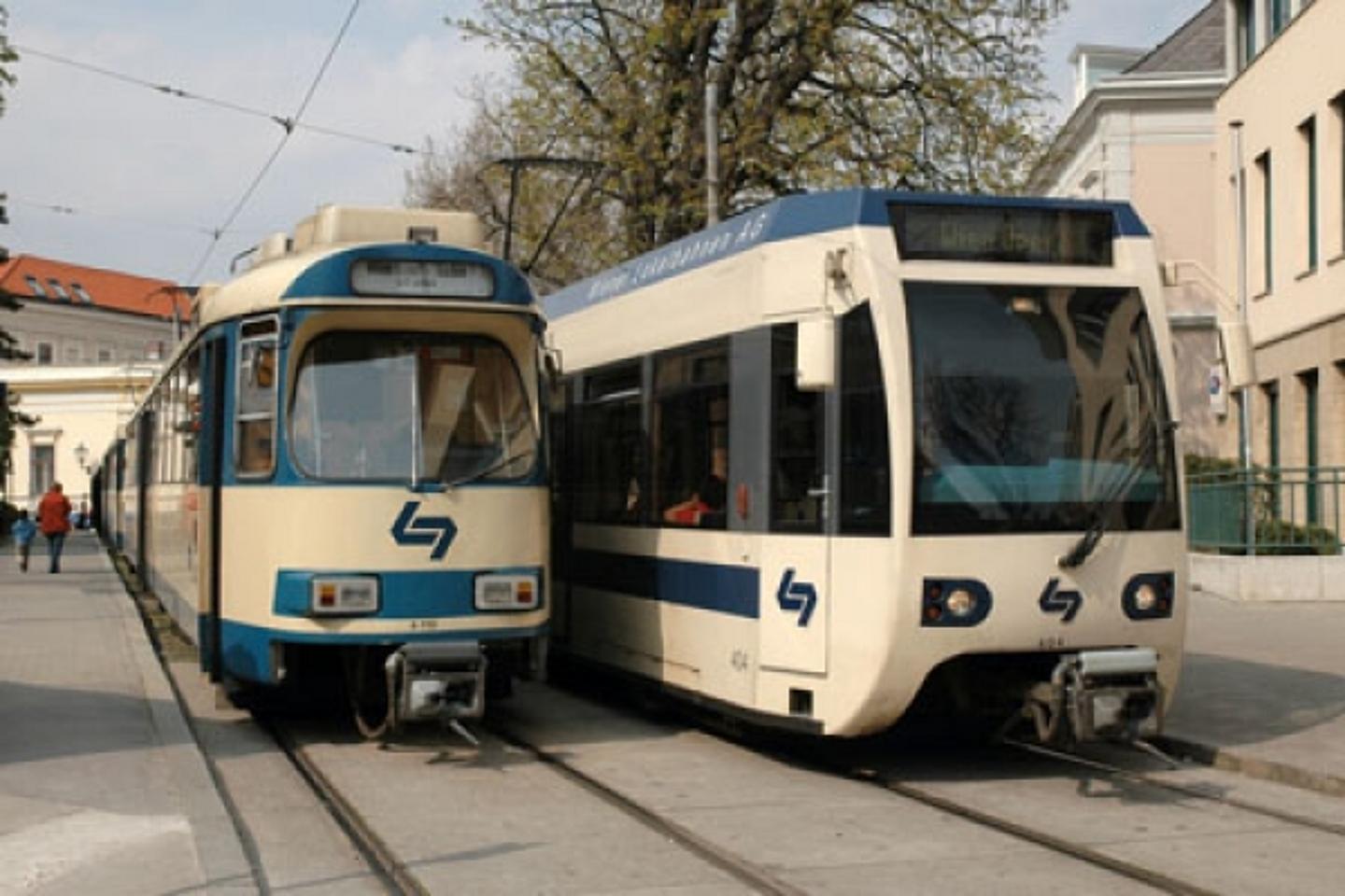 Alter und neuer Niederflur Zug der Badner Bahn neben einander auf den Schienen