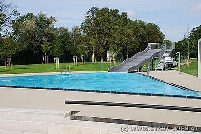 Ein blauer Pool mit Rutsche im Sonnenschein