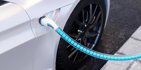 Ladekabel mit grafischer Darstellung des Stroms in einem weißen E-Auto