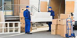 Männer mit Truck laden eine Couch auf den Umzugswagen