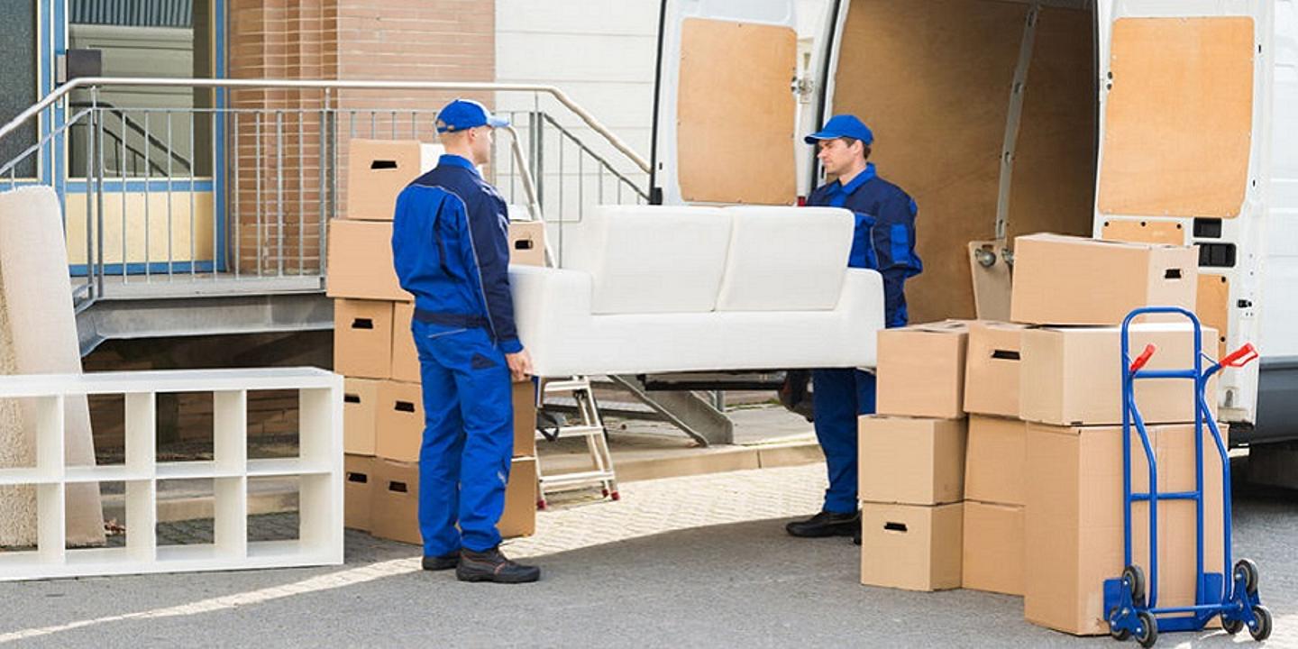 Männer mit Truck laden eine Couch auf den Umzugswagen