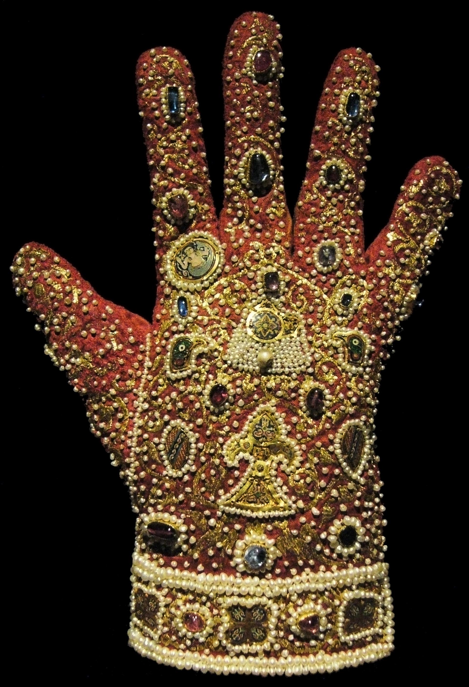 Bild von mit allerhand wertvollen Steinen besticktem Handschuh.