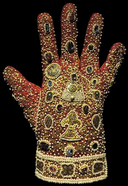 Bild von mit allerhand wertvollen Steinen besticktem Handschuh.