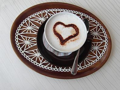 Café mit Milchschaum und Herz darin in der Tasse