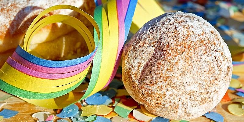 Krapfen auf dem Tisch mit Konfetti und Luftschlangen