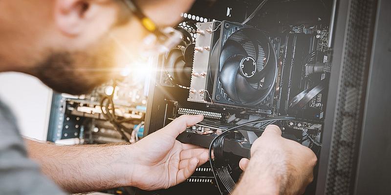 Wiener Reparaturbon wird österreichweiter Reparaturbonus Mann repariert Computer. Reparaturbon fördert die Reparatur von Altgeräten.