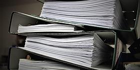 Informationsfreiheitsgesetz Aktenordner aufeinander gestapelt.