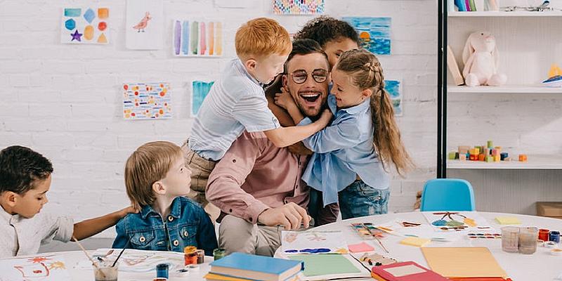 Mann wird von vielen Kindern umarmt