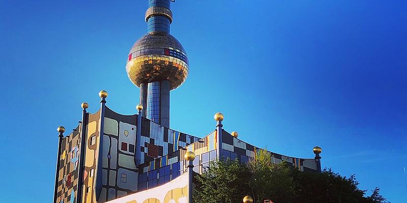 Fernwärme Wien Gebäude von Architekt Hundertwasser mit blauem Himmel