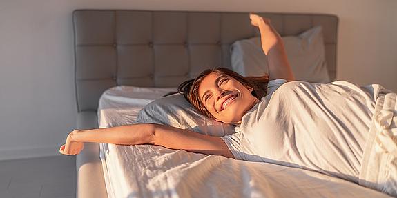 Frau hat super geschlafen und streckt sich genüßlich in der Morgensonne