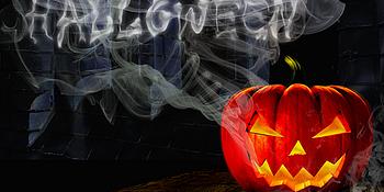 Halloween Leuchtender Kürbis vor schwarzem Hintergrund