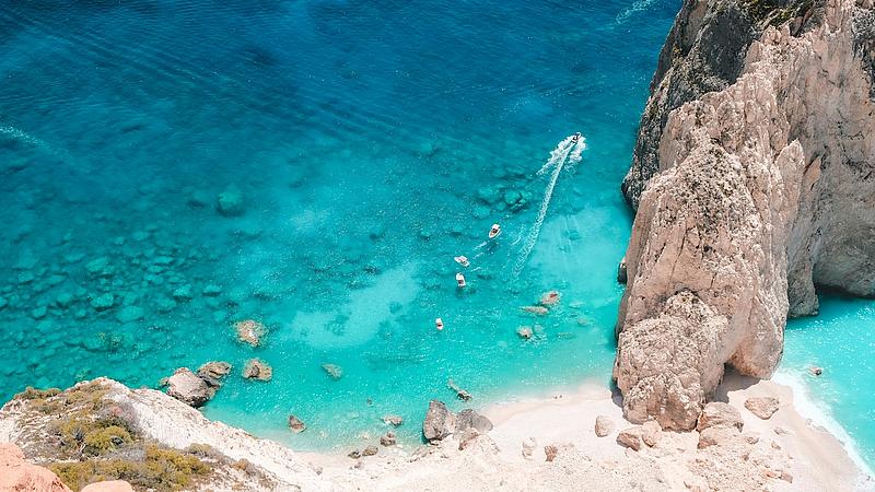 blick von oben auf eine türkisfarbene Bucht mit Strand