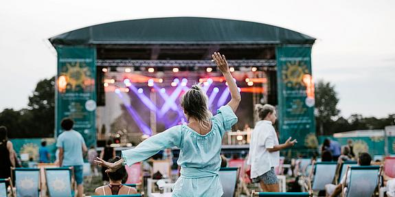 Frau tanzend von hinten, im Hintergrund eine der Wiener Kultursommer-Bühnen