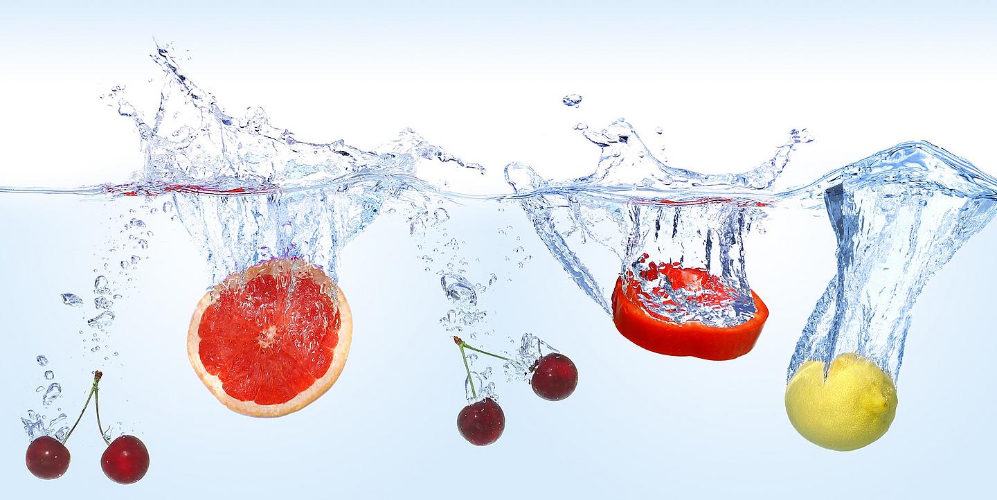 Fünf Früchte, die in reines Wasser fallen 
