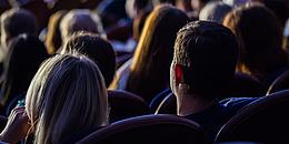 Menschen sitzen im Dunkeln und sehen sich einen Film an
