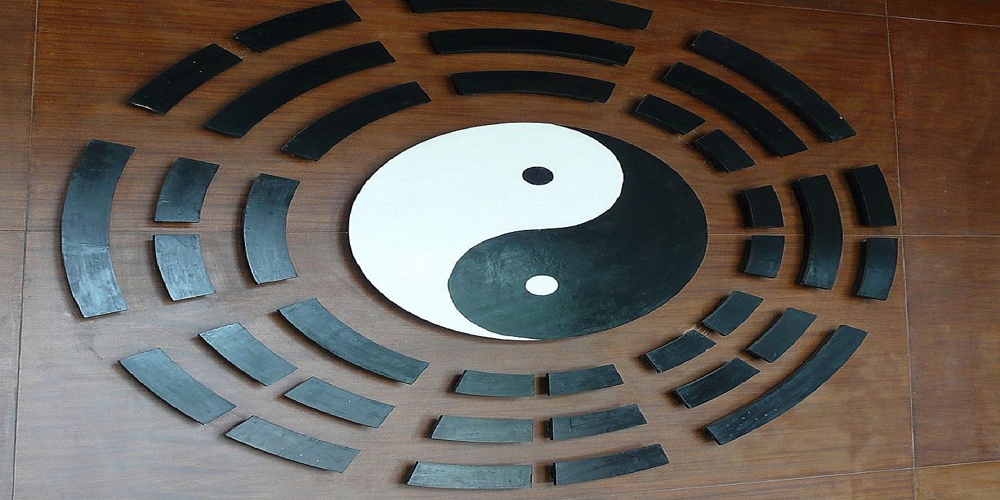 Ying und Yang Zeichen auf einer braunen Wand