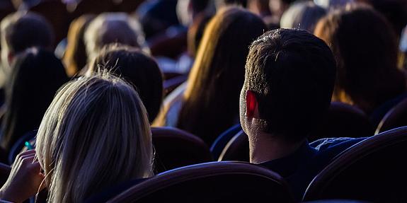 Menschen sitzen im Dunkeln und sehen sich einen Film an