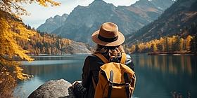 Frau sitzt in Herbstkulisse und genießt ihren Urlaub