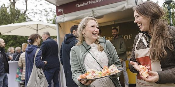 Zwei Frauen mit Kostproben am Genussfestival in Wien.