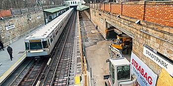 Die Baustelle der Station Stadtpark. Eine U-Bahn fährt durch die Station, welche gerade renoviert wird. 