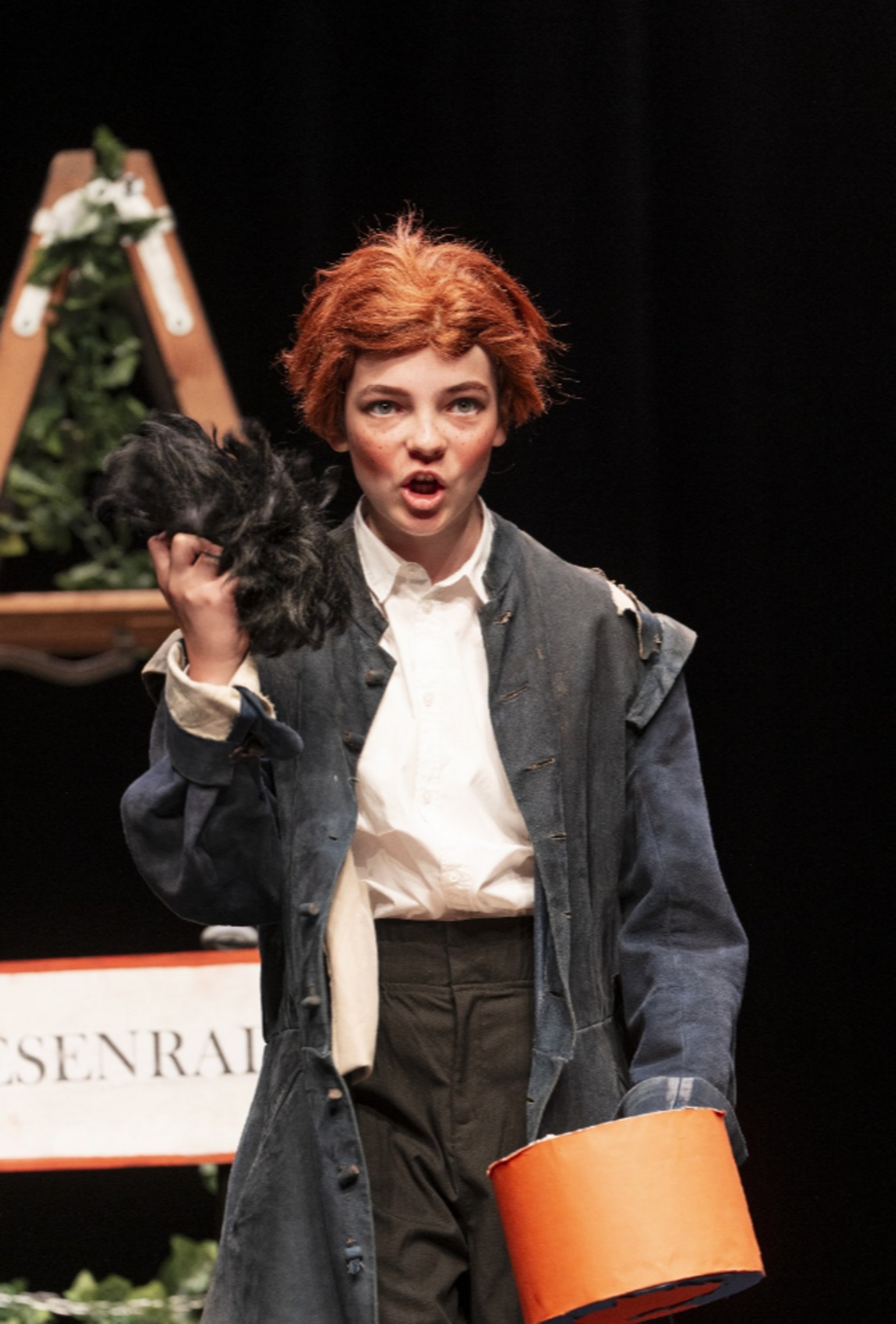Kind mit roter Perücke bei Theaterspiel