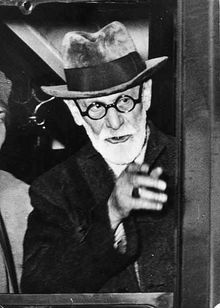 Älterer Mann mit weißem Bart, runder Brille und einem elegantem Hut.