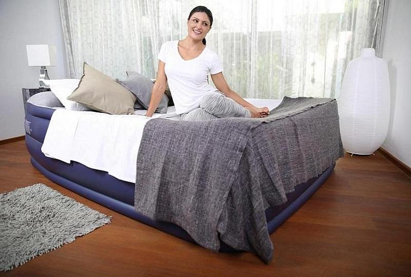 aufblasbares Bett auf dem eine Frau sitzt
