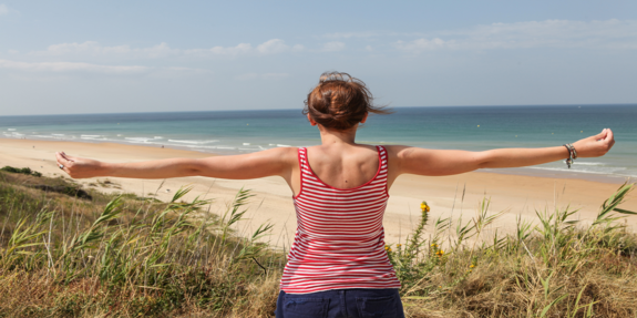 Mädchen mit ausgestreckten Armen am Strand