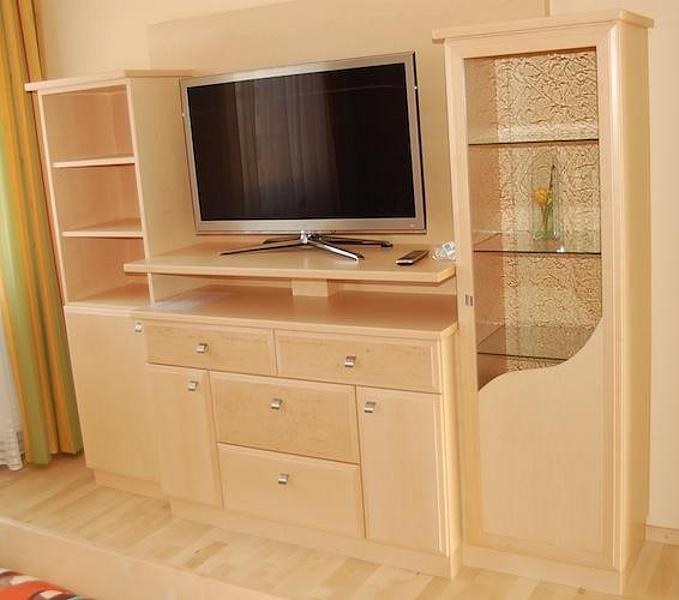 Fernsehschrank aus hellem Vollholz mit Unterbau und 2 flankierenden Stehkästen mit Fächer und Glastür