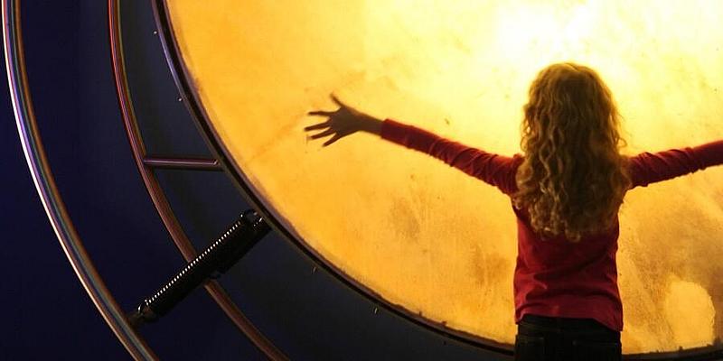 Überdimensionale große Trommel in Gelb mit Kind davor
