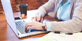 Mann sitzt daheim am Laptop und macht Home Office