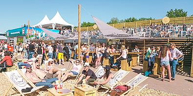 Viele Menschen, die in der Sonne auf Liegestühlen liegen