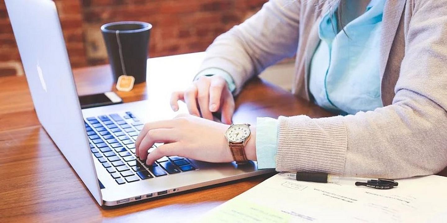 Mann sitzt daheim am Laptop und macht Home Office