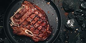Gut gebratenes Steak auf einem schwarzen Teller