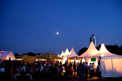 Weiße Zelte vor einer klaren blauen Nacht mit Mond am Horizont
