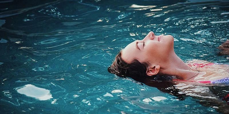 Hitze im Sommer Frau liegt im Wasser und genießt es