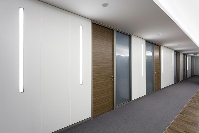 Trennwand mit weißer Beschichtung, Holztüren und Glaselementen