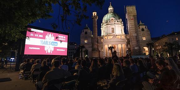 Karlskino bei Nacht vor beleuchteter Karlskirche