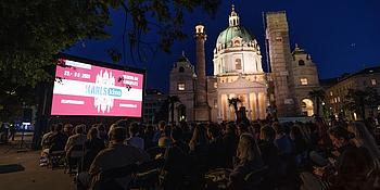 Karlskino bei Nacht vor beleuchteter Karlskirche