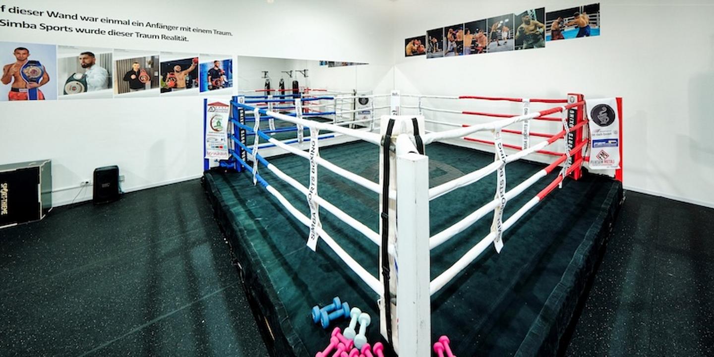 Boxring mit Fotos von Boxern im Hintergrund