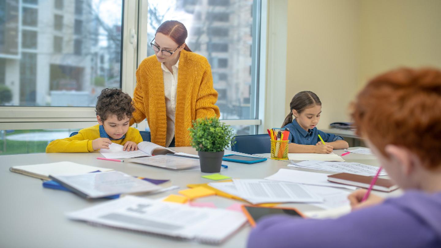 Nachhilfelehrerin sitzt mit Schüler im Nachhilfeinstitut