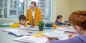 Nachhilfelehrerin sitzt mit Schüler im Nachhilfeinstitut