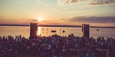 Ein Sonnenuntergang, den viele Menschen vom Strand aus beobachten